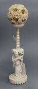 A Chinese ivory puzzle ball with figural stand, early 20th century height 23cm