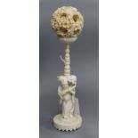 A Chinese ivory puzzle ball with figural stand, early 20th century height 23cm