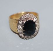 A 1960's textured 18ct gold, sapphire and diamond oval cluster ring, size L.