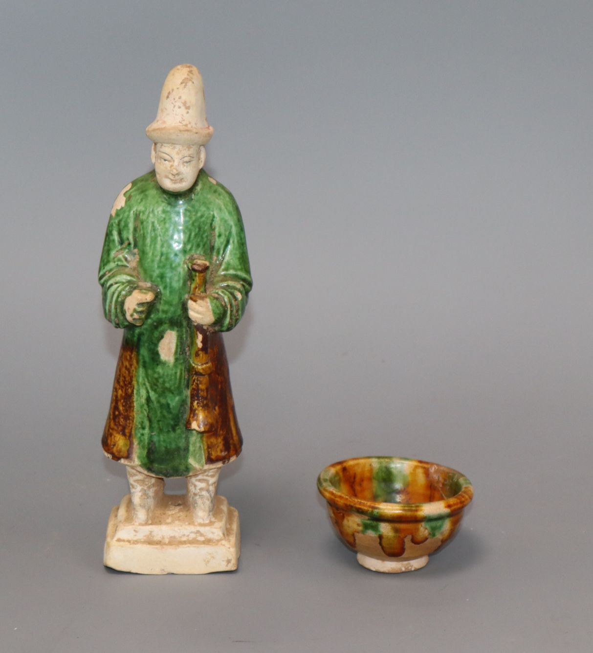 A Chinese green and rust glazed figure and a similar cup, Ming and Tang dynasty