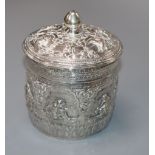 An Indian embossed white metal lidded jar, 10cm.