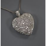 A modern pierced white metal and pave set diamond heart shaped pendant on an 18ct white gold fine