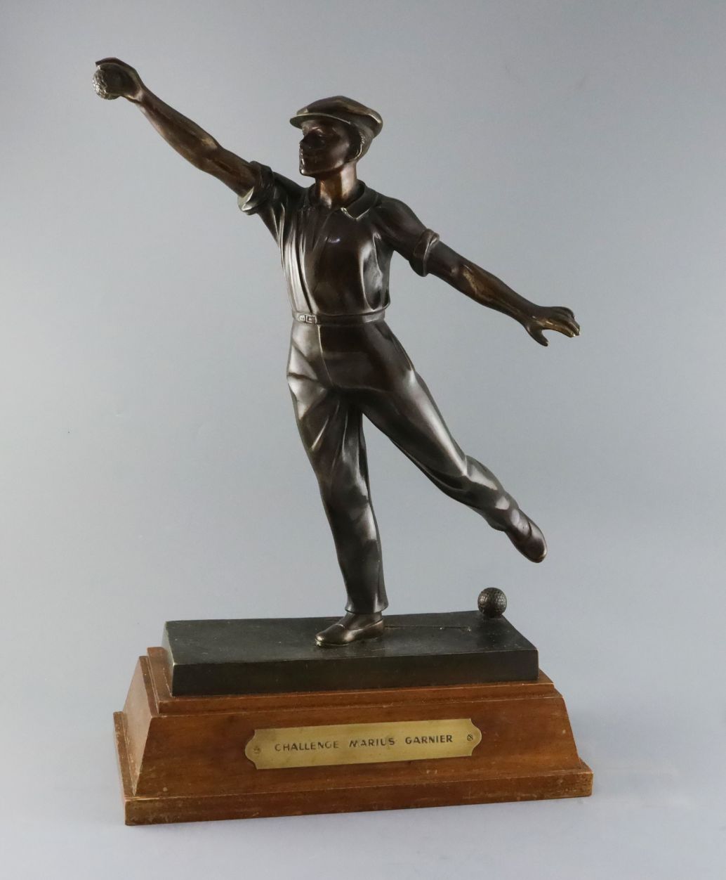 Émile Grégoire (1871-1948). A bronze boulle trophy, depicting a boulle player about to cast a throw,