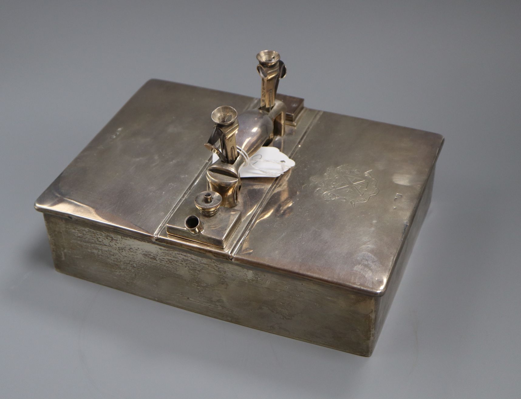 A late Victorian silver smoker's compendium, modelled as a double lidded box, with single handle,
