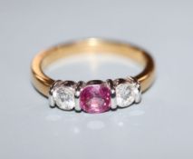 A modern 18ct gold, pink sapphire and diamond three stone ring, size M.