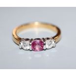 A modern 18ct gold, pink sapphire and diamond three stone ring, size M.