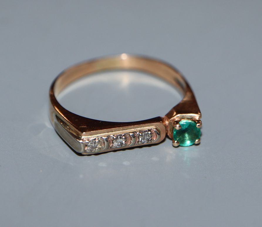 A yellow metal, single stone emerald and channel set three stone diamond ring, size M.