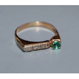 A yellow metal, single stone emerald and channel set three stone diamond ring, size M.