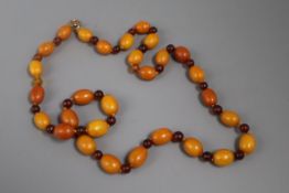 A single strand graduated oval amber bead necklace, with circular bead spacers, gross weight 38