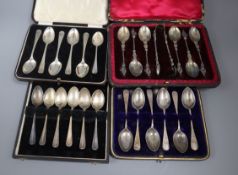 Four cased sets of six late Victorian and later silver teaspoons including one with sugar tongs.