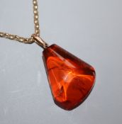 An amber pebble pendant, on a 9ct chain, pendant 34mm.