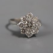 A modern 18ct white gold and nine stone diamond cluster ring, the central stone with an