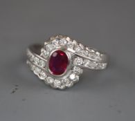 A modern stylish 18ct white gold, ruby and diamond oval cluster ring, with diamond set shoulders,