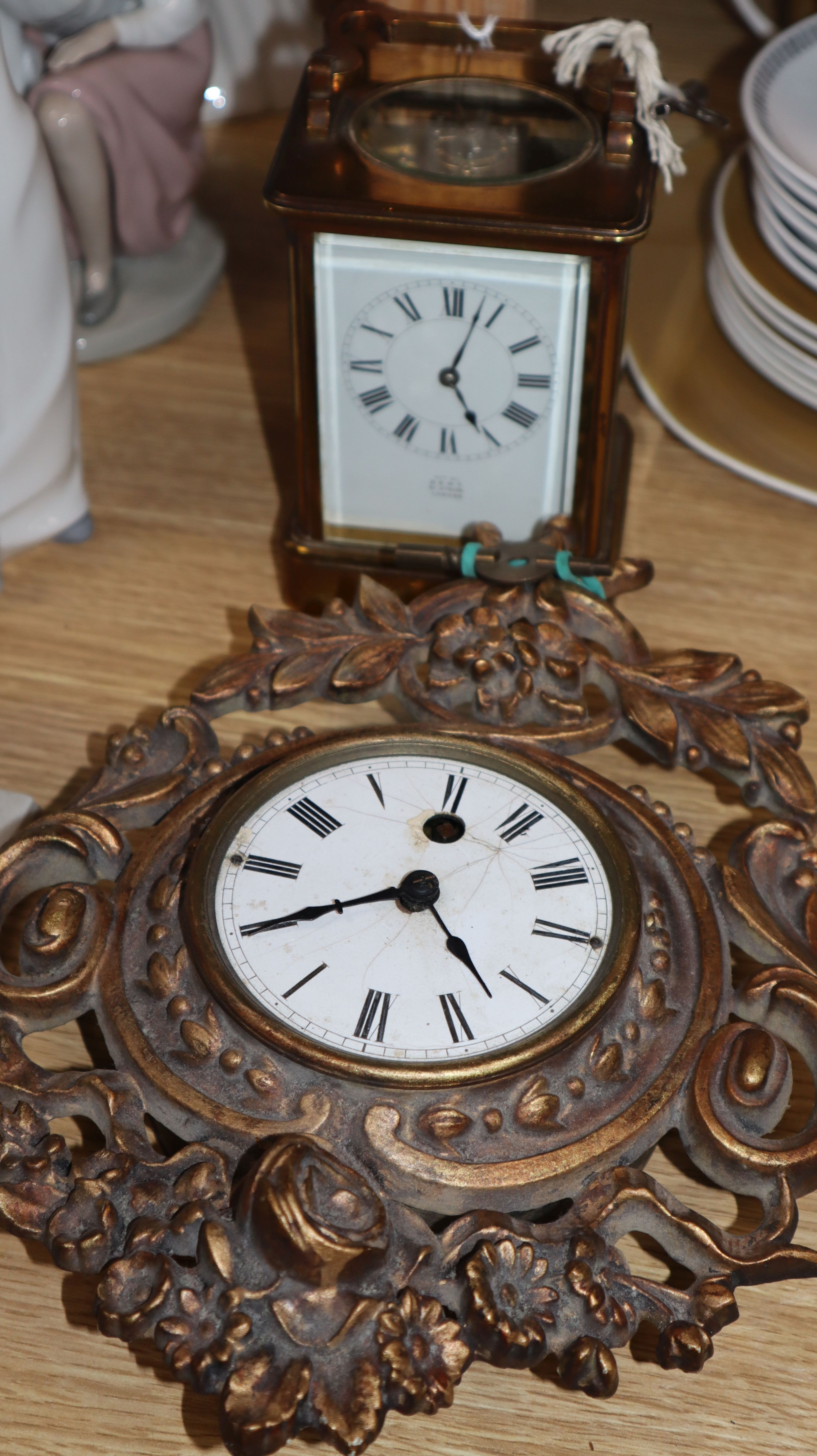 An early 20th century lacquer brass carriage clock and a small Cartel type timepiece