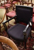 An ebonised Empire style elbow chair