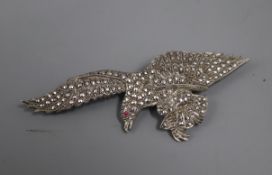 A white metal and marcasite set eagle brooch, with red paste eye, in fitted box, 80mm.