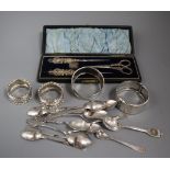 A silver bangle, three silver napkin rings, a small quantity of silver teaspoons and a cased