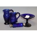 Two George III honeycomb moulded blue glass jugs, a blue glass double ended scent bottle and an