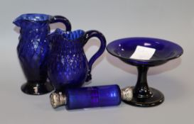 Two George III honeycomb moulded blue glass jugs, a blue glass double ended scent bottle and an