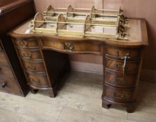 A George III style mahogany serpentine fronted kneehole desk, fitted nine small drawers W.115cm