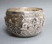 An early 20th century Burmese embossed white metal bowl, the base engraved with two seated
