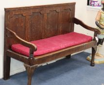 A mid 18th century oak settle, with panelled back L.148cm