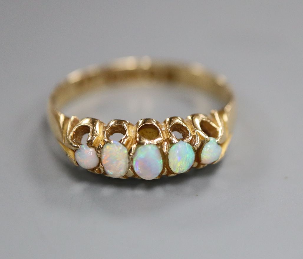 An Edwardian 18ct gold and graduated five stone white opal half hoop ring, size O.