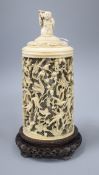 A late 19th century Chinese carved ivory lidded jar on a wood stand