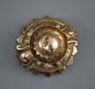 A Victorian embossed yellow metal brooch, with glazed back, 37mm.