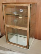 A small glass display cabinet with sliding doors