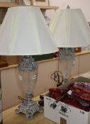 A pair of silvered metal and cut glass table lamps, shades over