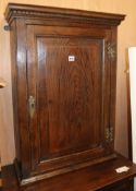 An 18th century oak hanging cupboard with fielded panelled door H.80cm