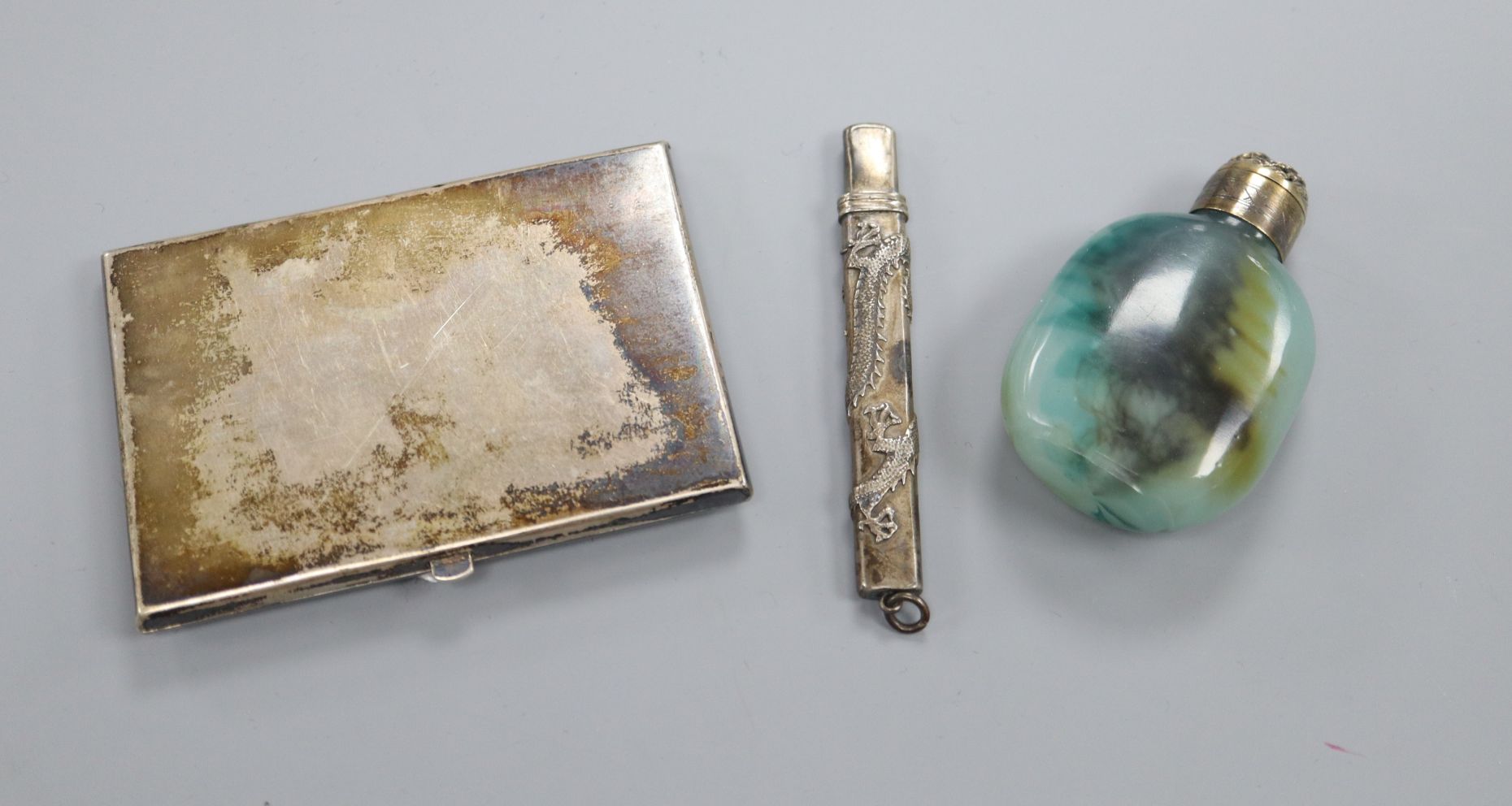 A Chinese white metal cigarette case, a mounted snuff bottle and a Chinese white metal pencil