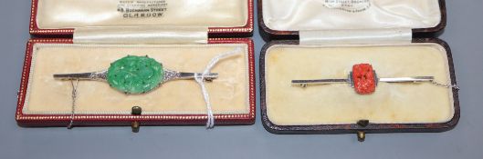 An Art Deco style 9ct white metal bar brooch set with diamonds flanking a carved jade plaque and a