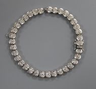 A modern 750 white metal and diamond set tennis bracelet (a.f.), 17.5cm.