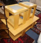 A beech two tier coffee table, with inset central glass panels and a pair of matching, smaller