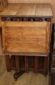 An Edwardian oak revolving bookcase, with incorporated adjustable reading slope W.54cm