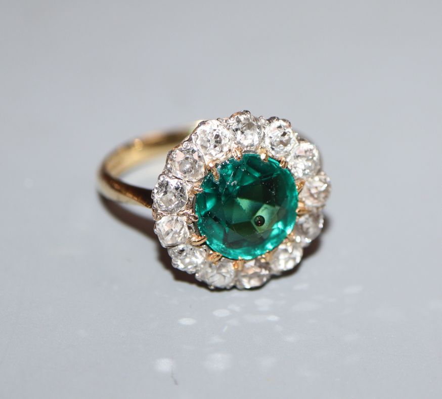 An 18ct, green garnet topped doublet and diamond cluster ring, size L.