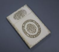 A Chinese ivory card case, carved with vignettes of figures in pavilions and foliate edges (one edge