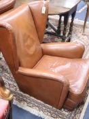 A pair of mid century design tan leather wing chairs