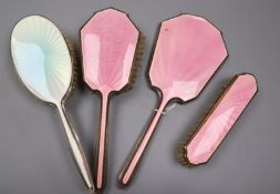 A George VI silver and pink guilloche enamel three piece mirror and brush set, Birmingham, 1947