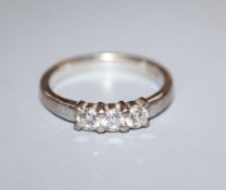 A modern 18ct white gold and three stone diamond ring, with a total approximate diamond carat weight