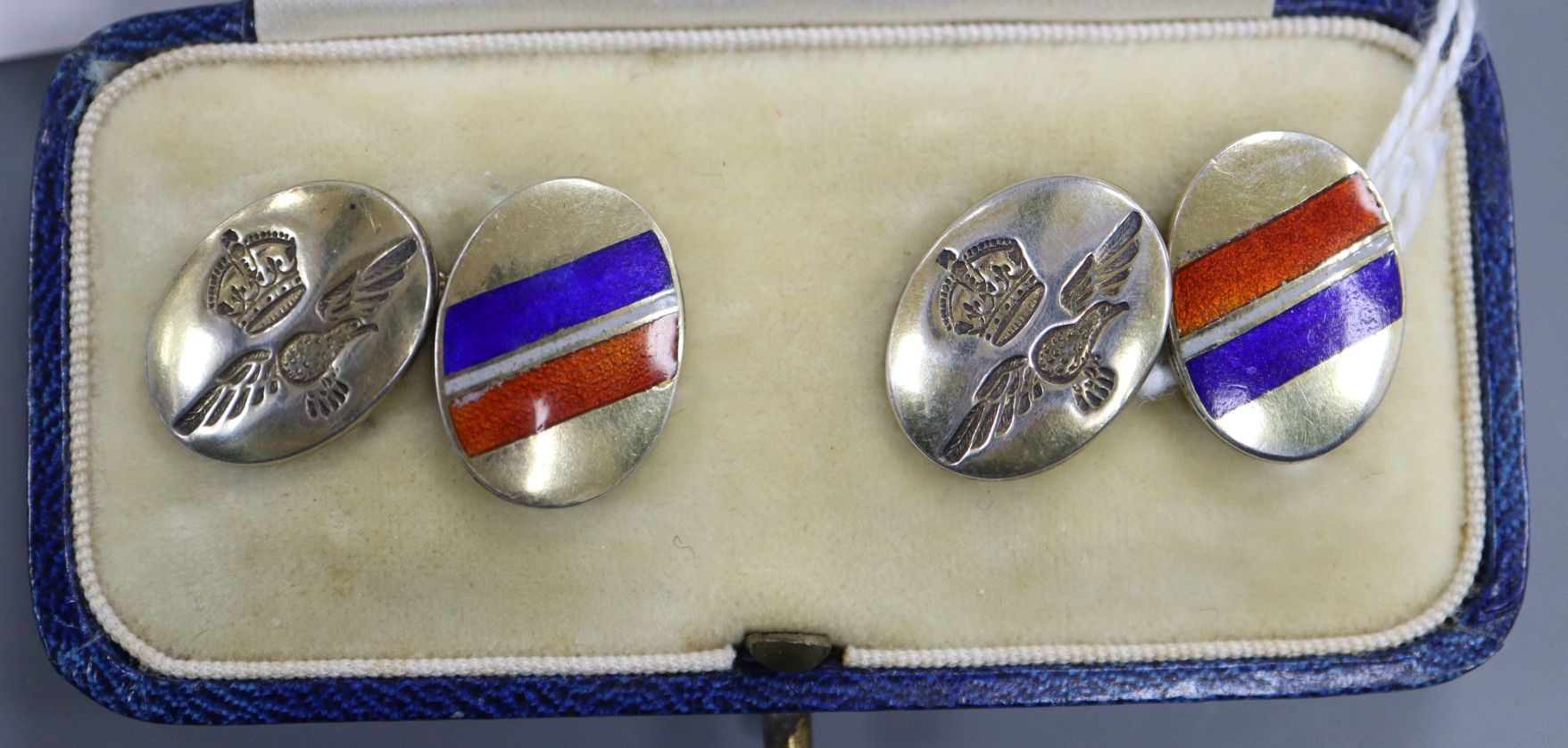 A cased pair of sterling and three colour enamel military related oval cufflinks.