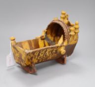 A 19th century documentary slipware model of a cradle, initialled SP and dated 1865, length 25cm (