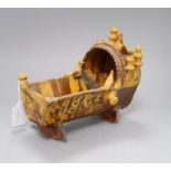 A 19th century documentary slipware model of a cradle, initialled SP and dated 1865, length 25cm (