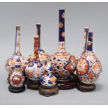 Six Japanese Imari bottle vases and two Imari gourd vases and hardwood stands tallest 22cm