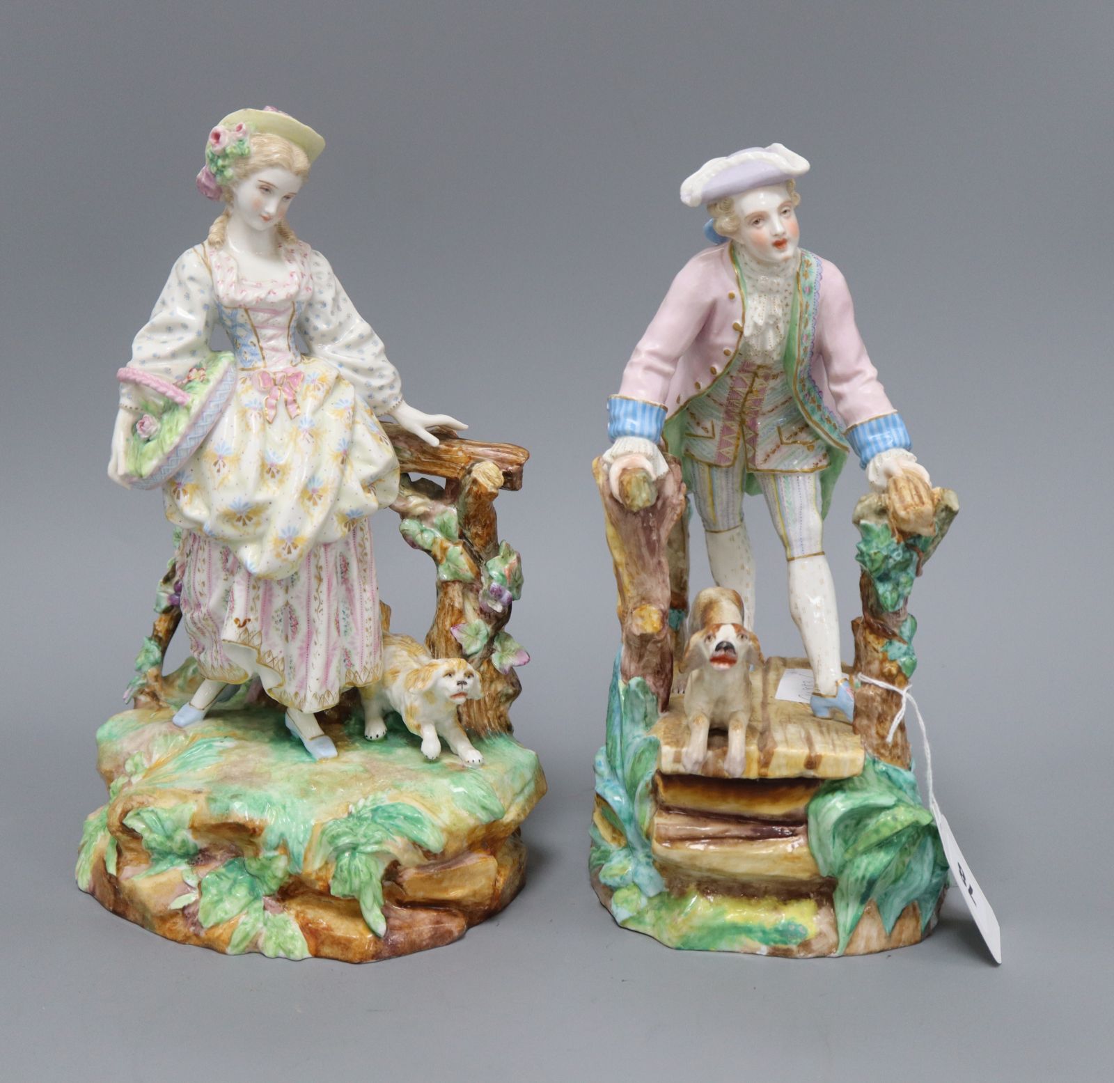 A pair of Paris porcelain figures of a man and his dog on a bridge, and a lady and her dog tallest