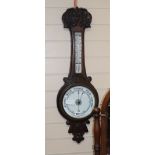 An Edwardian oak wheel barometer and thermometer H.82cm