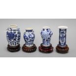 Four 19th century Chinese blue and white small vases, with hardwood stands tallest 9.5cm