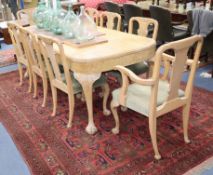 A Queen Anne style figured walnut dining table and eight dining chairs (two with arms) table L.